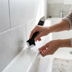 Smoothing a fresh caulk line along a bathtub with the CaulkSmooth tool
