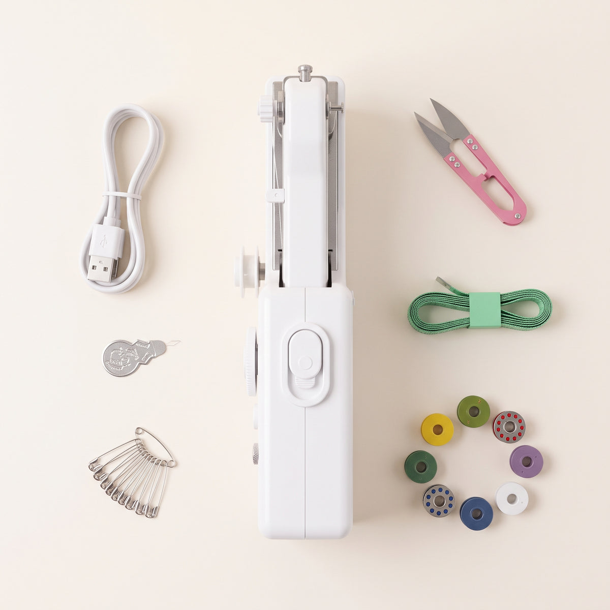 Handheld sewing machine with USB cable, snips, tape measure, bobbins, safety pins and needle threader